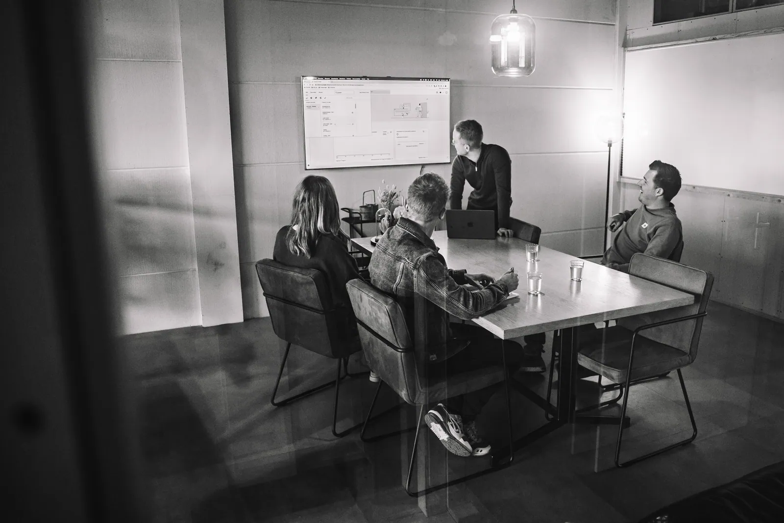 Het team overlegt aan tafel bij WeDeCom